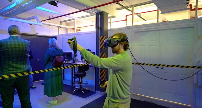 A man standing in a taped-off area wearing a VR headset